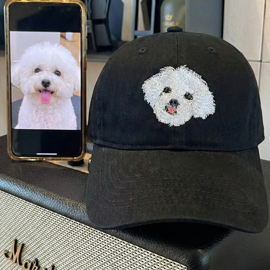 Black cap with dog embroidery next to a phone displaying a dog photo, on a Marshall amplifier.