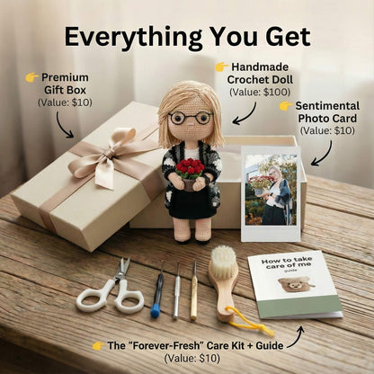 Gift set with a crochet doll, photo card, gift box, and care kit on a wooden surface.